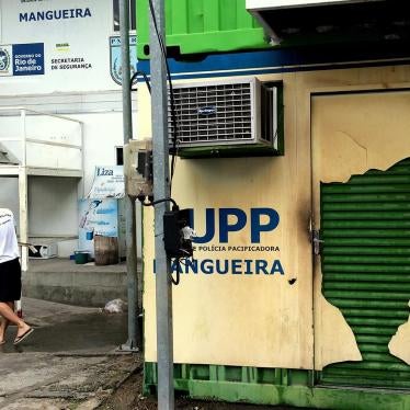 A military police officer cleans the area around the Pacifying Police Unit (UPP) at the Mangueira favela on January 14, 2016. The UPP is made of metal shipping containers. © 2016 César Muñoz Acebes/Human Rights Watch