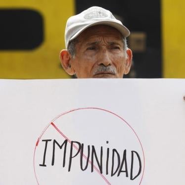 A man holds a banner that reads "impunity", during a protest outside the Special Military Security Unit base in San Salvador, August 24, 2011.