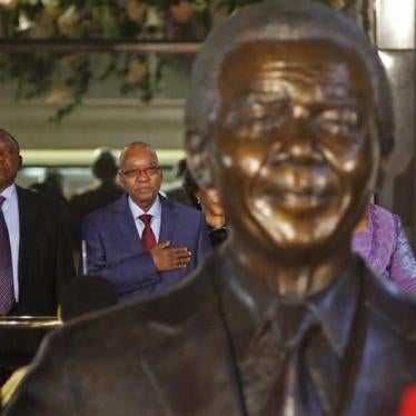 South African President Jacob Zuma (2nd L) stands behind a statue of former South African President Nelson Mandela outside Parliament in Cape Town June 17, 2014.