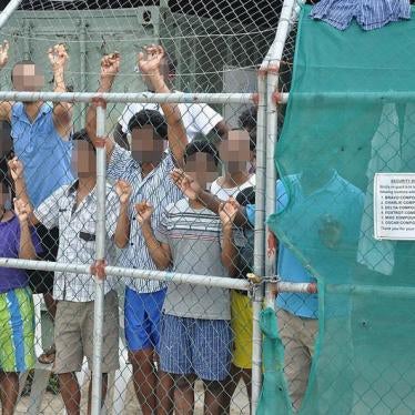 Asylum-seekers look through a fence at the Manus Island detention centre in Papua New Guinea March 21, 2014. 
