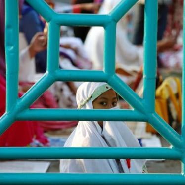 A girl is seen through a fence before prayers for the Muslim holiday of Eid Al-Adha on a street in Jakarta, Indonesia September 12, 2016. 