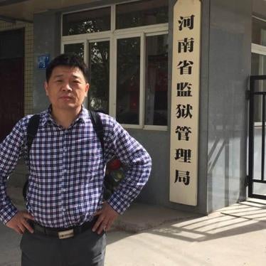 Li Jinxing poses at the entrance of the Bureau of Prison Administration, Zhengzhou, Henan province. 