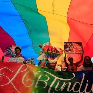 Supporters hold placards while marching under a rainbow flag during a LGBT Pride parade in metro Manila, Philippines June 25, 2016. 