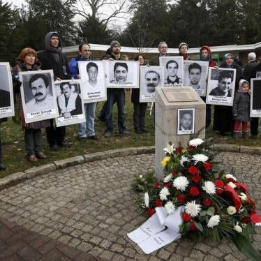 People hold pictures of the victims of the National Socialist Underground (NSU) group at the memorial to Halit Yozgat in Kassel, April 6, 2013.