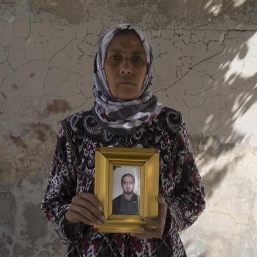 2)	Zakia Hassan holds a photo of her son, Ibrahim Hammud, 35, who detonated an explosive device when he stepped on a mattress as he returned to his house on August 12. 