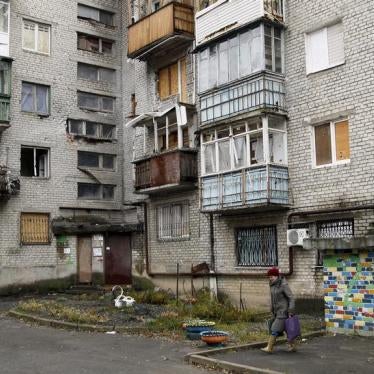 A woman walks out of a residential building that was damaged during battles between Ukrainian armed forces and Russian-backed separatists, in Donetsk, Ukraine November 25, 2015.
