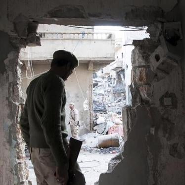 A member of the Libyan National Army, the armed forces allied with the Interim Government in al-Bayda, stands next to a hole on a wall during clashes with the Benghazi Revolutionaries Shura Council, an Islamist militia alliance, in Benghazi, Libya. 