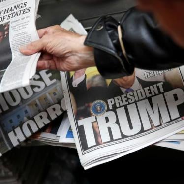 A man hands a newspaper to a customer at a news stand in New York, U.S., November 9, 2016.
