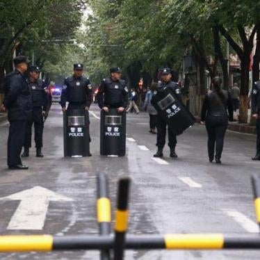 Policemen with riot gear stand guard behind a barricade near the site of an explosives attack in Xinjiang Uyghur Autonomous Region on May 23, 2014. 