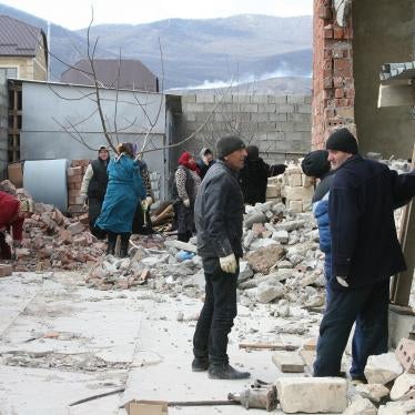 Local residents cleaning up the debris of a house destroyed in a counterinsurgency operation in Novyi Agachaul, Dagestan, February 2014.  © 2014 Varvara Pakhomenko