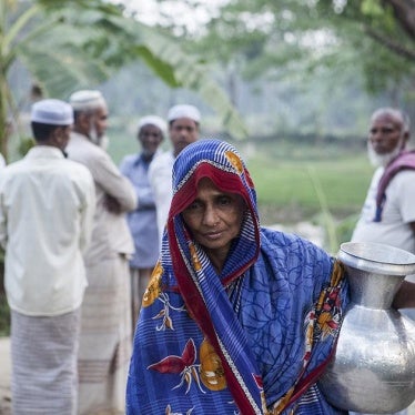 A woman bringing drinking water home in the evening. Balia in Ulania Union (in Barisal District). March 17, 2016. 