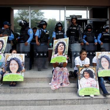 Indigenous people hold posters with a photograph of slain environmental rights activist Berta Caceres while sitting in front of riot policemen during a protest to demand justice in Tegucigalpa, Honduras, on March 17, 2016. 
