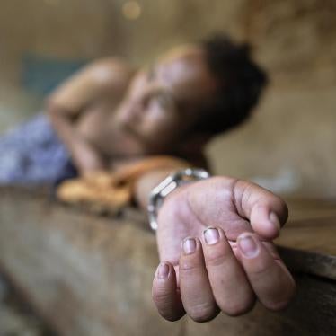 A man with a psychosocial disability lies chained at the wrist on a platform bed at the Bina Lestari healing center in Brebes, Central Java. All residents of the healing center are chained. © 2015 Andrea Star Reese for Human Rights Watch 