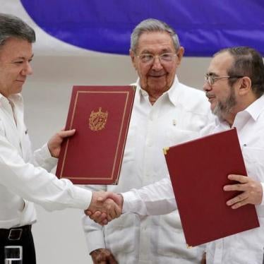 Cuba's President Raul Castro (C), Colombia's President Juan Manuel Santos (L) and FARC rebel leader Rodrigo Londono, better known by his nom de guerre Timochenko, react after the signing of a historic ceasefire deal between the Colombian governm