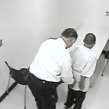 A still from a police interrogation video shows a 13-year-old boy being handcuffed. The pressure of the interrogation caused him to confess to a murder he did not commit. 