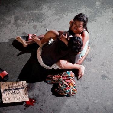 Jennelyn Olaires, 26, cradles the body of her partner, who was killed on a street by a vigilante group, according to police, in a spate of drug related killings in Pasay city, Metro Manila, Philippines on July 23, 2016. A sign on a cardboard found near th