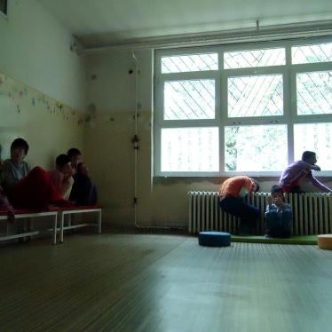 A living room in Veternik Institution where children and adults with disabilities spend most of their days. There are no toys, education materials, or carpets on the floor. The only available source of stimulation is a TV attached to the wall. 