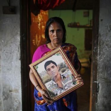 Fatema holds a picture of her son Nurul Karim, one year after both he and her daughter Arifa died in the April 24, 2013 Rana Plaza collapse. 