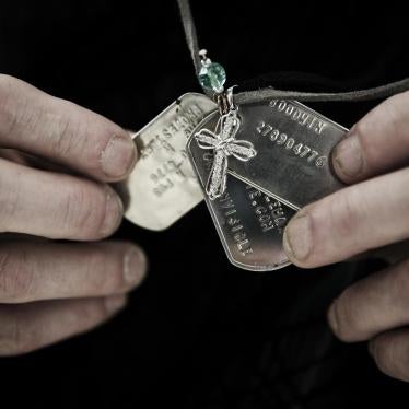 Gary Noling holding dogtags belonging to his daughter, Carri Goodwin, a rape victim who died of acute alcohol intoxication less than a week after receiving an Other Than Honorable discharge from the Marines.