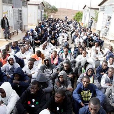 Migrants, detained after trying to reach Europe, sit on the ground of a detention camp in Gheryan, Western Libya, on December 1, 2016.