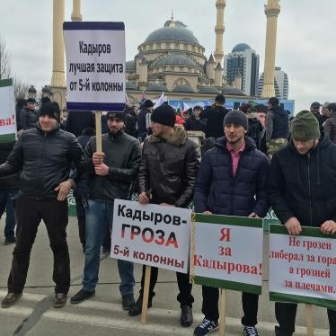 Men standing with signs “I’m for Kadyrov” and “Kadyrov is the Scourge of the Fifth Column” at a mass pro-Kadyrov rally organized by Chechen authorities in Grozny in January 2016.