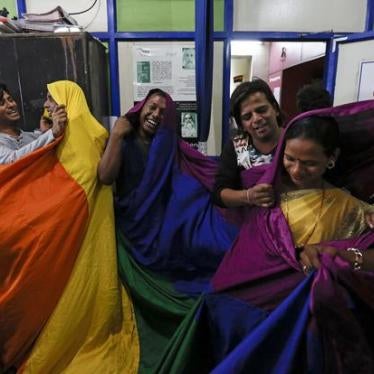 LGBT rights activists in Mumbai cover themselves with a rainbow flag after the Supreme Court announced on February 2, 2016 that it would hear an appeal of its 2013 decision that upheld a discriminatory law criminalizing same-sex relations. © 2016 Reuters