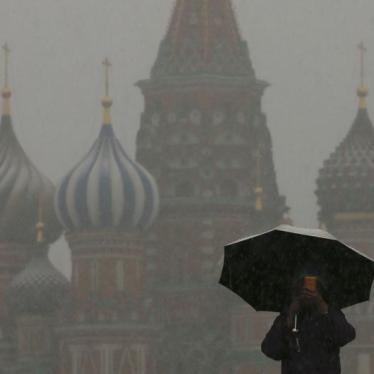 A man walks under an umbrella during a snowfall, with St. Basil's Cathedral seen in the background, in Red Square in central Moscow March 31, 2014.