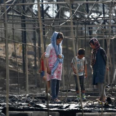 Asylum seekers stand among the remains of a burned tent at the Moria migrant camp, after a fire started in the camp ripped through tents and destroyed containers, on the island of Lesbos, Greece, September 20, 2016.
