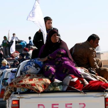 Displaced Iraqi civilians hold white flags as they flee a battle with the Islamic State in Kokjali village near Mosul, November 03, 2016.