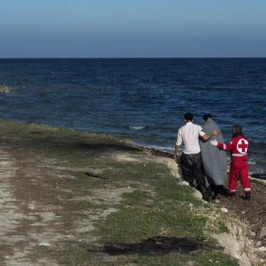 Member of Greek Red Cross helps an Afghan refugee who has just arrived from Turkey with an inflatable boat in the area of airport of Mytilene, Lesvos Island, Greece.