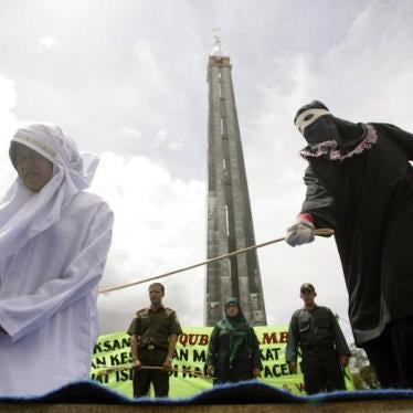 Murni Amris, an Acehnese woman, is caned as part of her sentence in the courtyard of a mosque in Aceh Besar district, Indonesia's Aceh province October 1, 2010.