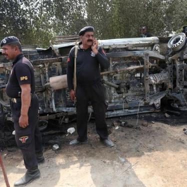 Policemen gather after an angry mob set ablaze a police van along a road in a protest following Thursday's suicide blast at the tomb of Sufi saint Syed Usman Marwandi, also known as the Lal Shahbaz Qalandar shrine, in Sehwan Sharif, Pakistan's southern Si