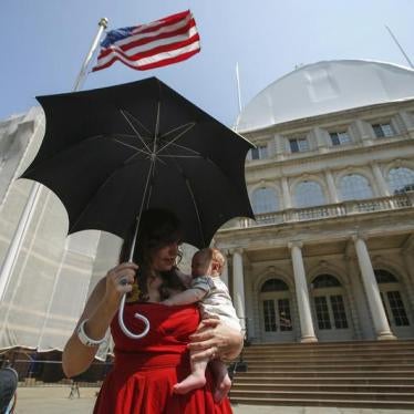 A mother holds her baby while attending a rally to raise public awareness and support for breastfeeding by the steps of New York City Hall in Manhattan, August 8, 2014.