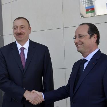 Azerbaijan's President Ilham Aliyev (L) shakes hands with his French counterpart Francois Hollande as they visit a local French school under construction in Baku, May 11, 2014.