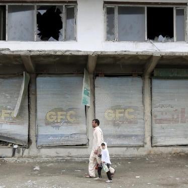 Residents walk past damaged shops after a suicide car bomb attack on a government security building in Kabul, Afghanistan April 19, 2016. 