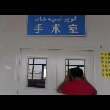 A man looks through a window on the door of an operating room as his wife undergoes a caesarean section at a hospital in Shaya county, Xinjiang Uighur Autonomous Region June 4, 2012.