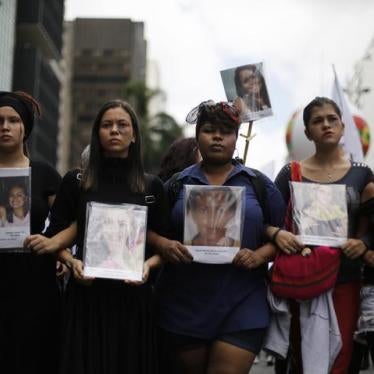 Women hold pictures of victims that died of domestic abuse against women, during a march to celebrate International Women's Day in Sao Paulo March 8, 2014. 