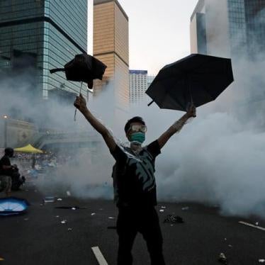 A protester raises his umbrellas after riot police fire tear gas to disperse protesters in Hong Kong, September 28, 2014