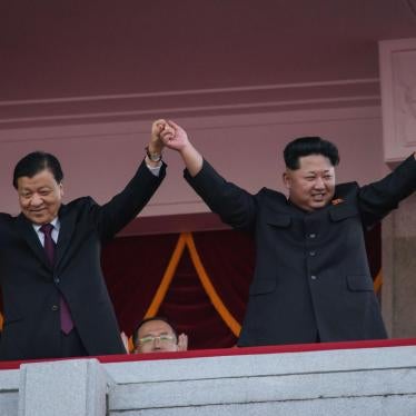 North Korea's leader Kim Jong-Un (R) and Chinese Politburo standing committee member Liu Yunshan (L) wave from a balcony towards participants of a mass military parade at Kim Il-Sung square in Pyongyang on October 10, 2015