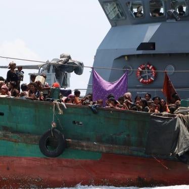 A Thai navy vessel tows a boat with migrants away from Thailand, in waters near Koh Lipe island in southern Thailand May 16, 2015.
