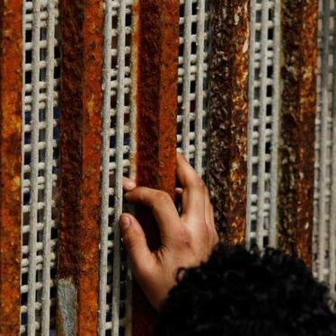 A man, who was deported from the U.S. seven months ago, touches the fingertips of his nephew across a fence separating Mexico and US.