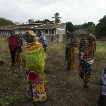 Women look on as residents talk to police officers after an attack in Panda Nguo, Lamu County on the northern coast of Kenya July 11, 2014. 