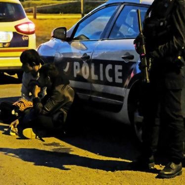 French police detain two migrants, one a 14-year-old boy, before dispersing a late-night food distribution in Calais on June 29, 2017. 