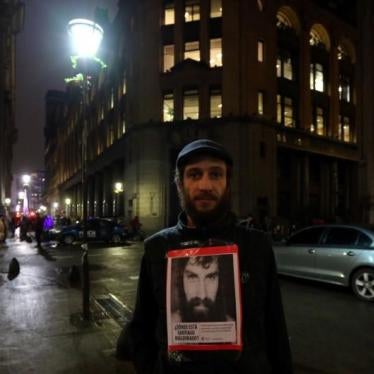A man poses for a photo with a portrait of Santiago Maldonado, during a demonstration to demand actions to find him in Buenos Aires, Argentina, August 11, 2017. 