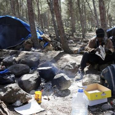 migrants sitting outside tent by morocco border