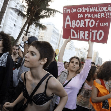 People participate in the SlutWalk protest on Copacabana Beach, here pope Francis will celebrate mass at night, in Rio de Janeiro, July, 2013. The sign reads "No more criminalization of women, abortion is a right". ©  REUTERS/Pilar Olivares 