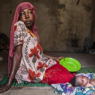 After returning from Cameroon, a Nigerian woman sits with her new-born in the militarized displaced persons camp in Banki, northeast Nigeria, where a Boko Haram attack in early September killed 18 civilians.