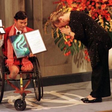 The winner of the Nobel Peace Prize Jody Williams bows in front of Cambodian Tun Channereth, who holds the International Campaign to Ban Landmines diploma and medal, on her way to receive the Nobel Peace Prize in Oslo City Hall, December 10, 1997.
