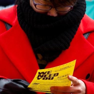 A woman reads a company flyer at an open air job fair for college graduates and the general public in the centre of Shijiazhuang, Hebei province, China, February 6, 2017.