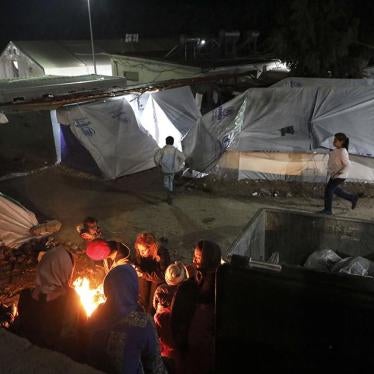 Migrants and asylum seekers gathering around a fire, inside the Moria hotspot on Lesbos island, Greece.